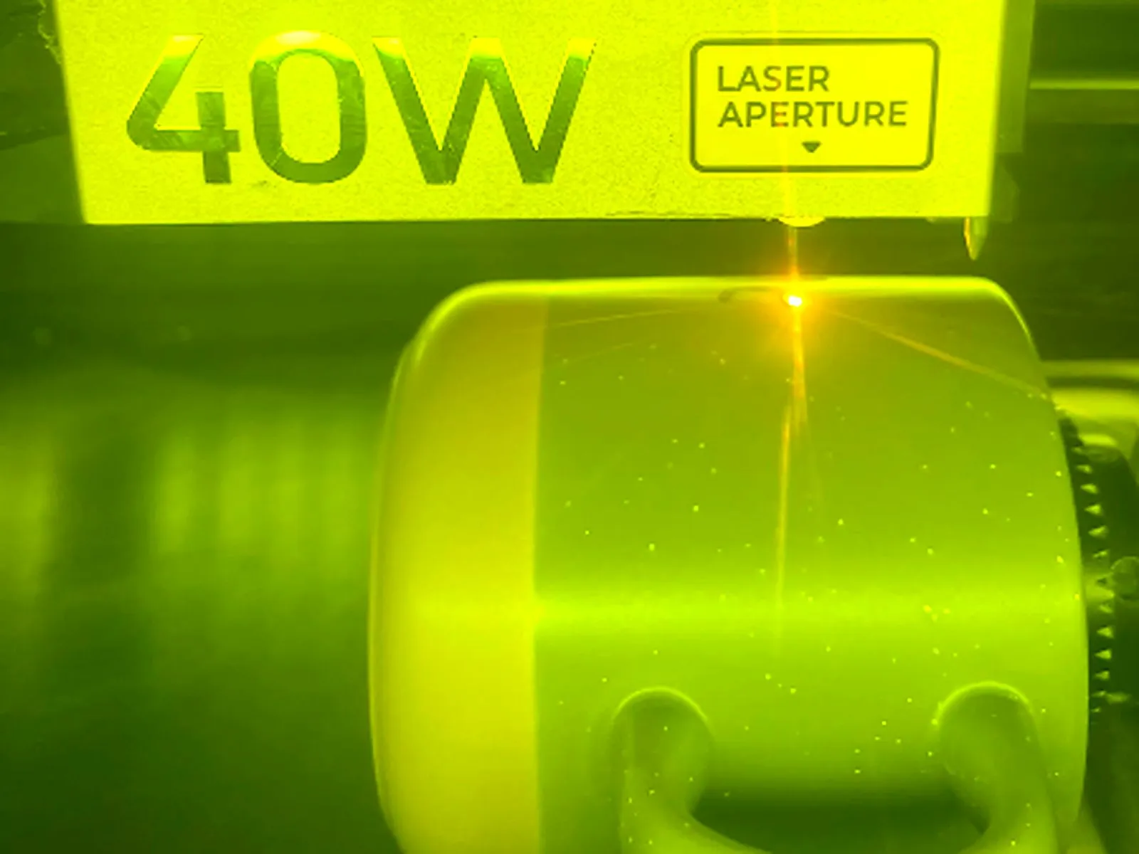 Lasergravur in Aktion: Der Laser graviert eine Tasse in der Drehvorrichtung
