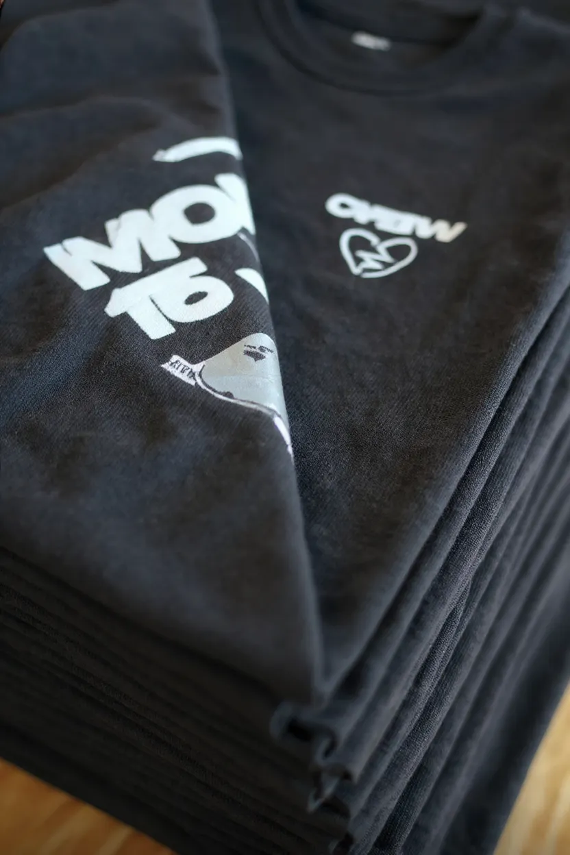 Stapel bedruckter T-Shirts aus einer Merch-Kleinauflage bei Bielefeld Druck